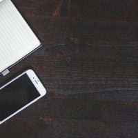 一位年轻编辑在书架前整理稿件与笔记，午后阳光从侧窗照进室内，氛围安静